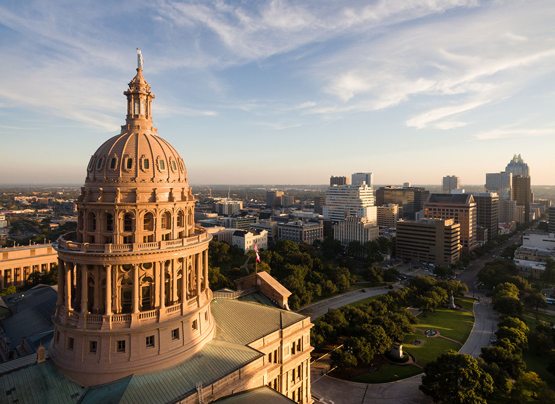 Austin, TX - Aerial View of the Capital Building in Downtown Austin Texas at Sunset with Views of a Park and Surrounding Commercial Buildings in the Background