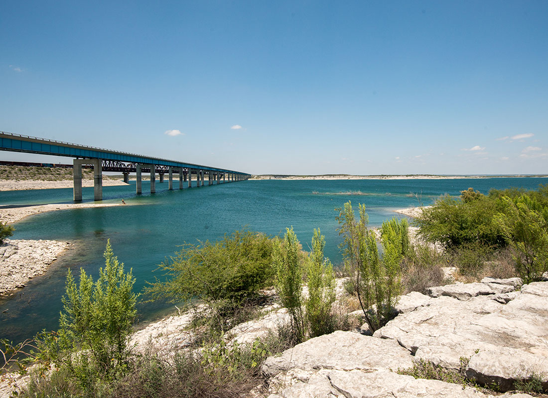 Del Rio, TX - Scenic View of a Blue Lake with a Bridge Across the Water in a State Park in Del Rio Texas on a Sunny Day